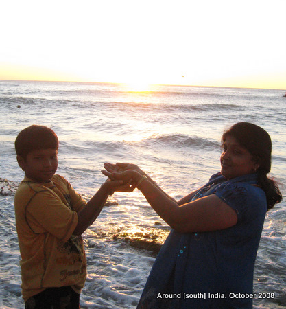 a mother and her son try to bring the rising sun on their palms