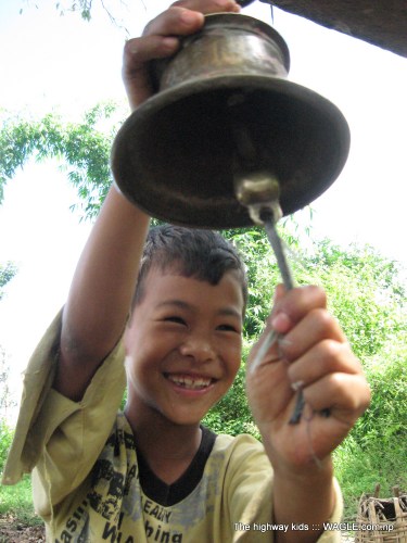 highway kids of nepal. kid playing a bell