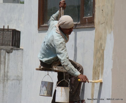 man at work: A labourer paints a house in New Delhi's Jangpura Extension neighbourhood