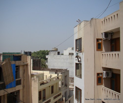 man at work: A labourer paints a house in New Delhi's Jangpura Extension neighbourhood