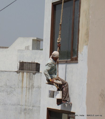 man at work: A labourer paints a house in New Delhi's Jangpura Extension neighbourhood