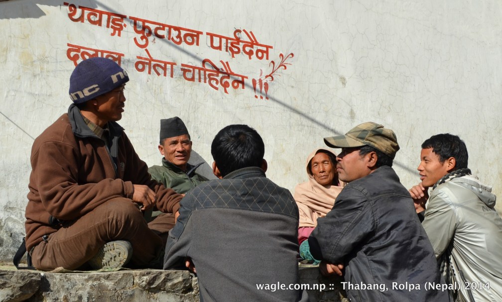 In a recent sunny afternoon the people of Thabang, Rolpa gathered to chat under a Maoist anti-election graffiti. 1st line: Don't divide Thabang; 2nd line: Middlemen leaders are not needed.