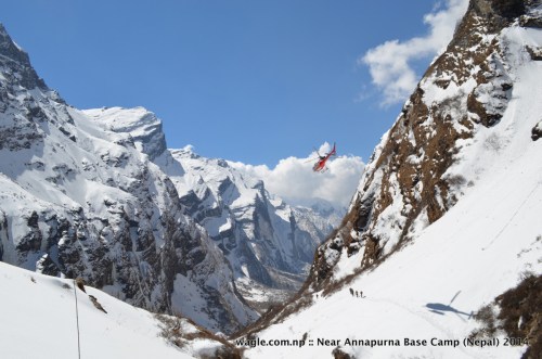 A helicopter flew over the trekkers who were approaching the Machhapuchhere Base Camp via the trail in the Modi Khola river valley-- as seen from Machhapuchhre Base Camp--with snow-capped Mardi Himal on the left