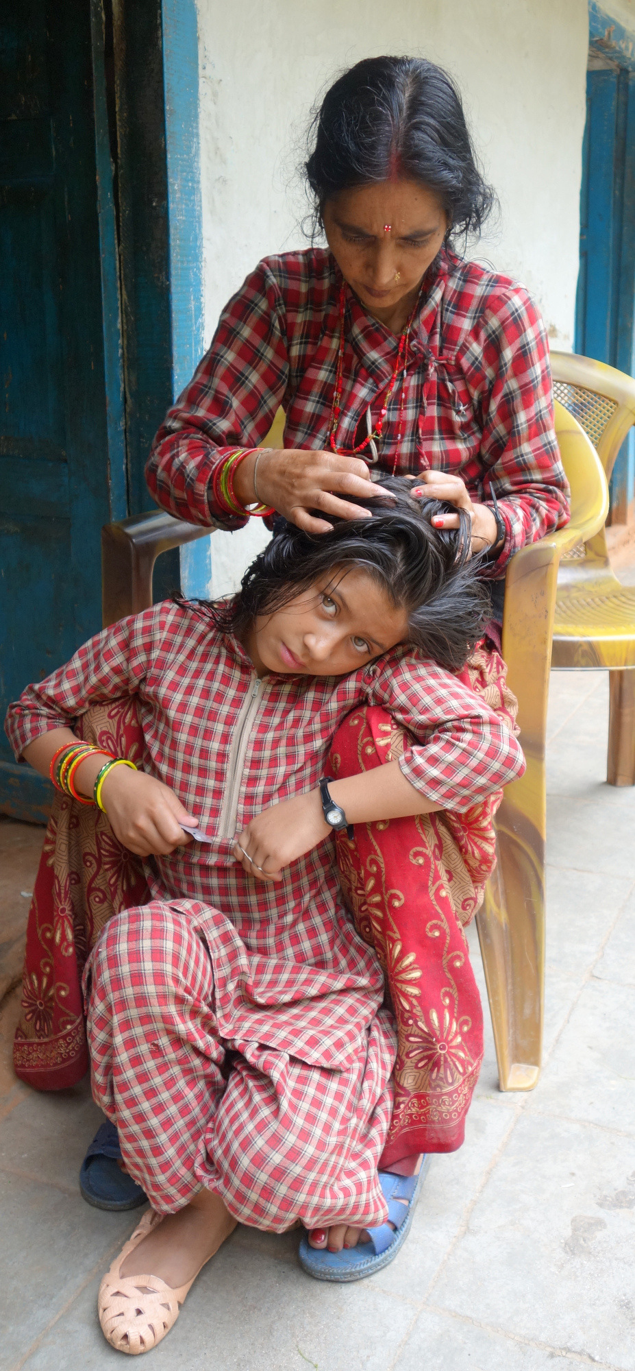 In Chandanpur village, a grandma looks for lice in her granddaughter’s hair.